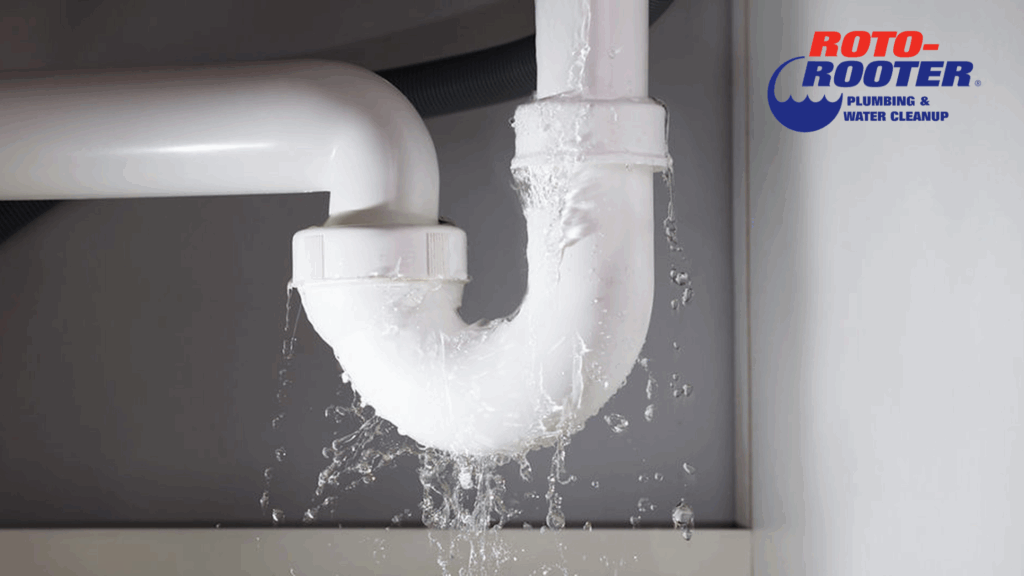Leaking white PVC pipe under a sink during plumbing emergency in Mobile, AL.