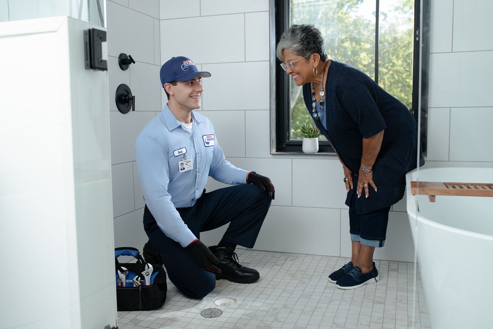 Roto-Rooter plumber talking with a homeowner about a slow shower drain
